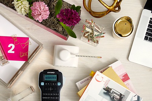 potted ombre pink white and purple hyacinth plant tank pencil sharpener books laptop computer paper clips stapler and tape roll on desk