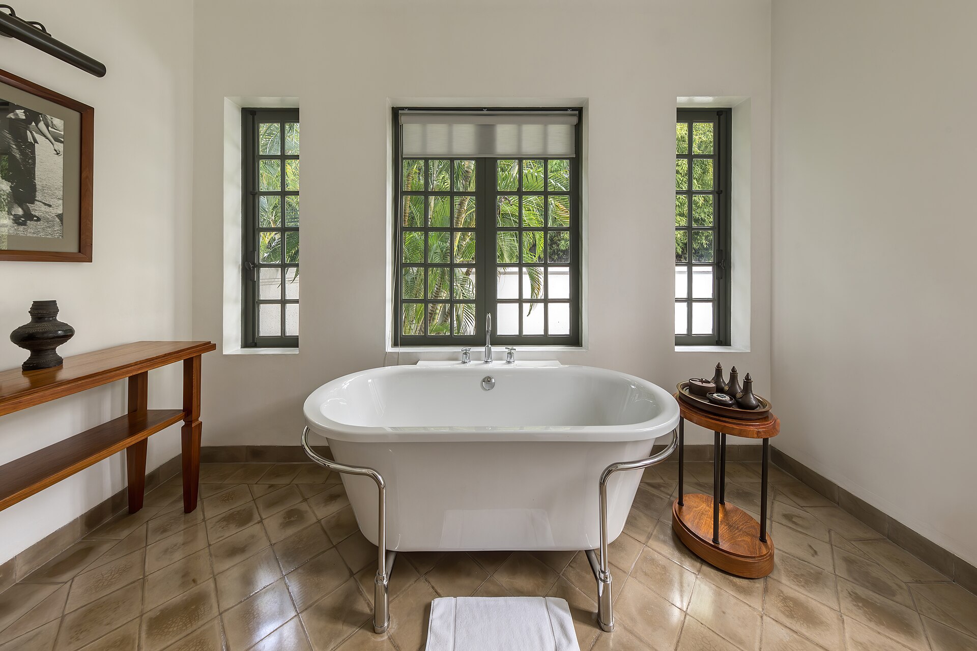 Bathtub of Khan Pool Suite in Amantaka luxury resort and hotel in Luang Prabang, Laos. Amantaka is one of the 34 properties operated by Aman Resorts, hospitality company founded by Indonesian hotelier Adrian Zecha in 1988, present in more than 20 countries. The hotel, located in a French colonial building, opened in September 2009. A boutique hotel, it contains 24 lavish suites, encircling a central courtyard and is designed with a mixture of traditional Lao furnishings and modern. The suites range in size from 70 to 120 square metres and include eight suites, four pool suites, eight Khan pool suites, two Mekong pool suites and two Amantaka pool suites. All of the rooms have a king-sized bed centre of the suites beneath a traditional high ceiling. They are painted in white and have mahogany or dark wood furnishings and windows. The rooms are reported to be between 1,100 USD and 1,900 USD a night.