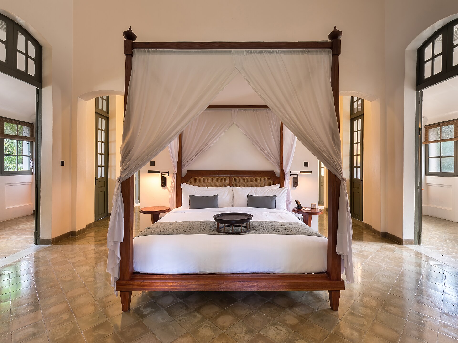 Canopy bed of Amantaka Suite in Amantaka luxury resort and hotel in Luang Prabang, Laos. Amantaka is one of the 34 properties operated by Aman Resorts, hospitality company founded by Indonesian hotelier Adrian Zecha in 1988, present in more than 20 countries. The hotel, located in a French colonial building, opened in September 2009. A boutique hotel, it contains 24 lavish suites, encircling a central courtyard and is designed with a mixture of traditional Lao furnishings and modern. The suites range in size from 70 to 120 square metres and include eight suites, four pool suites, eight Khan pool suites, two Mekong pool suites and two Amantaka pool suites. All of the rooms have a king-sized bed centre of the suites beneath a traditional high ceiling. They are painted in white and have mahogany or dark wood furnishings and windows. The rooms are reported to be between 1,100 USD and 1,900 USD a night.