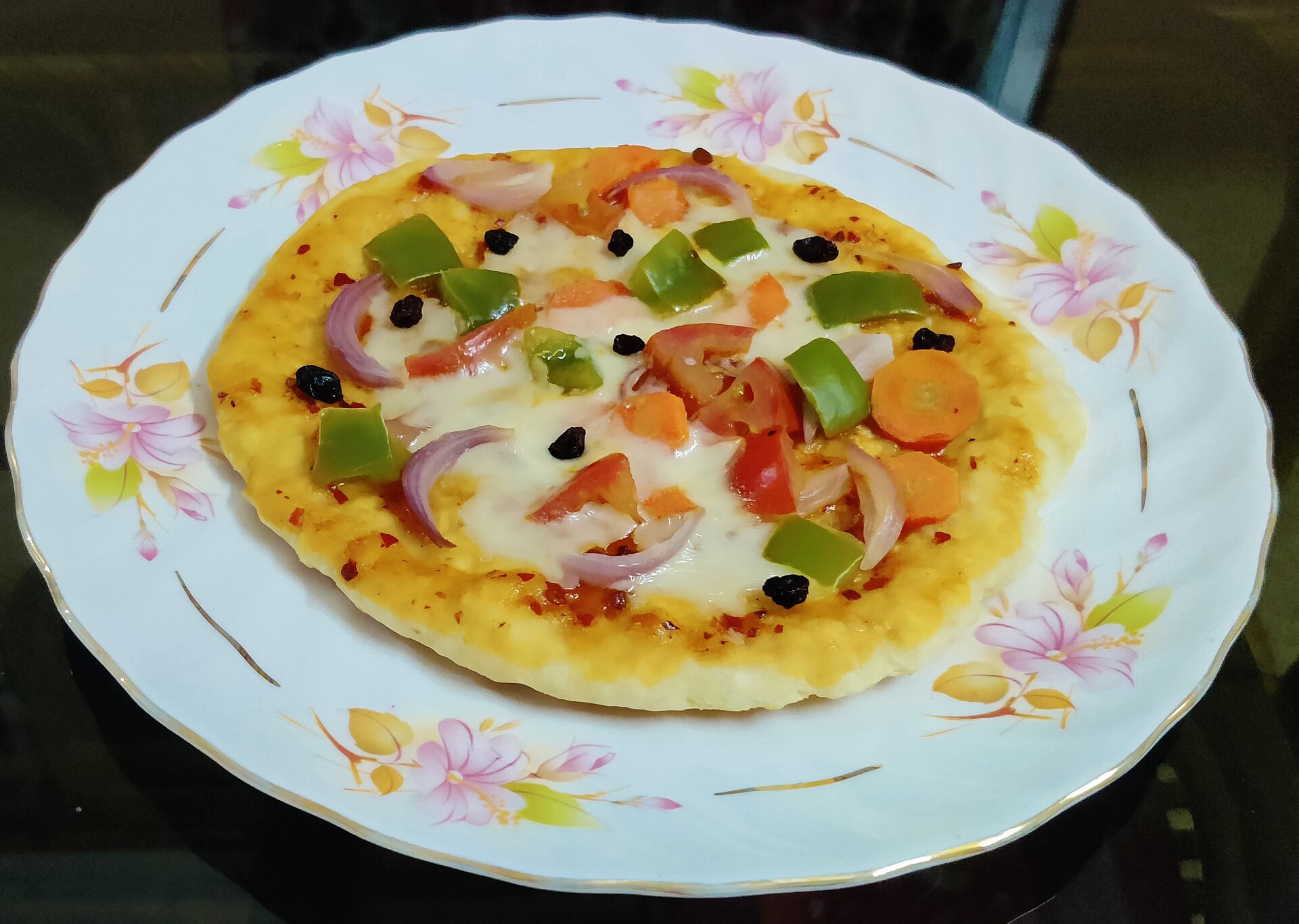 veg pizza recipe, topped with tomato, capcicum, onion, cheese. Nagaon, Assam.