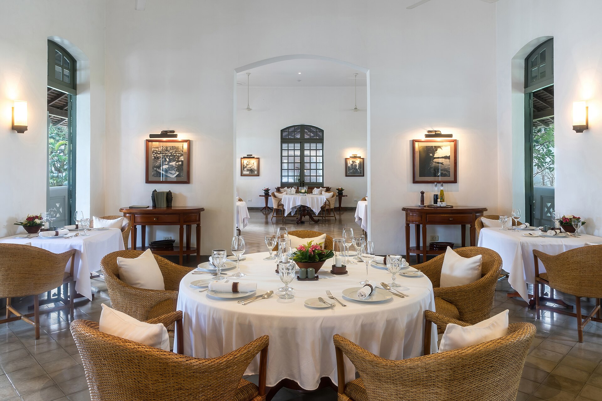 Restaurant room of Amantaka luxury resort and hotel in Luang Prabang, Laos, for breakfasts, lunches and dinners. This room is used as an annex to the pool terrace. Amantaka is one of the 34 properties operated by Aman Resorts, hospitality company founded by Indonesian hotelier Adrian Zecha in 1988, present in more than 20 countries. The hotel, located in a French colonial building, opened in September 2009. A boutique hotel, it contains 24 lavish suites, encircling a central courtyard and is designed with a mixture of traditional Lao furnishings and modern. The suites range in size from 70 to 120 square metres and include eight suites, four pool suites, eight Khan pool suites, two Mekong pool suites and two Amantaka pool suites. All of the rooms have a king-sized bed centre of the suites beneath a traditional high ceiling. They are painted in white and have mahogany or dark wood furnishings and windows. The rooms are reported to be between 1,100 USD and 1,900 USD a night.