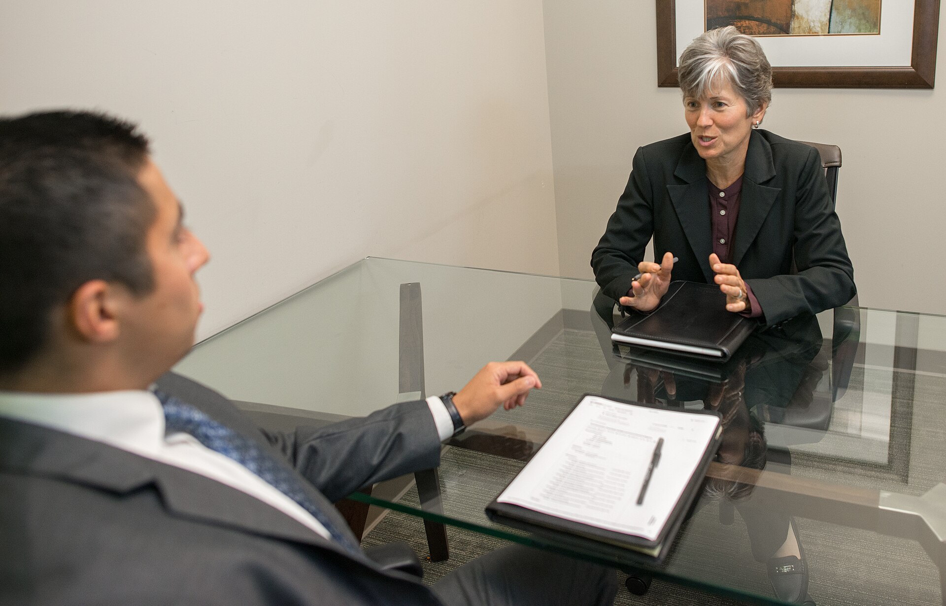Mature woman and young man having a discussion in a job interview. When using the image please provide photo credit (link) to: https://www.amtec.us.com per these terms: www.amtec.us.com/creative-commons