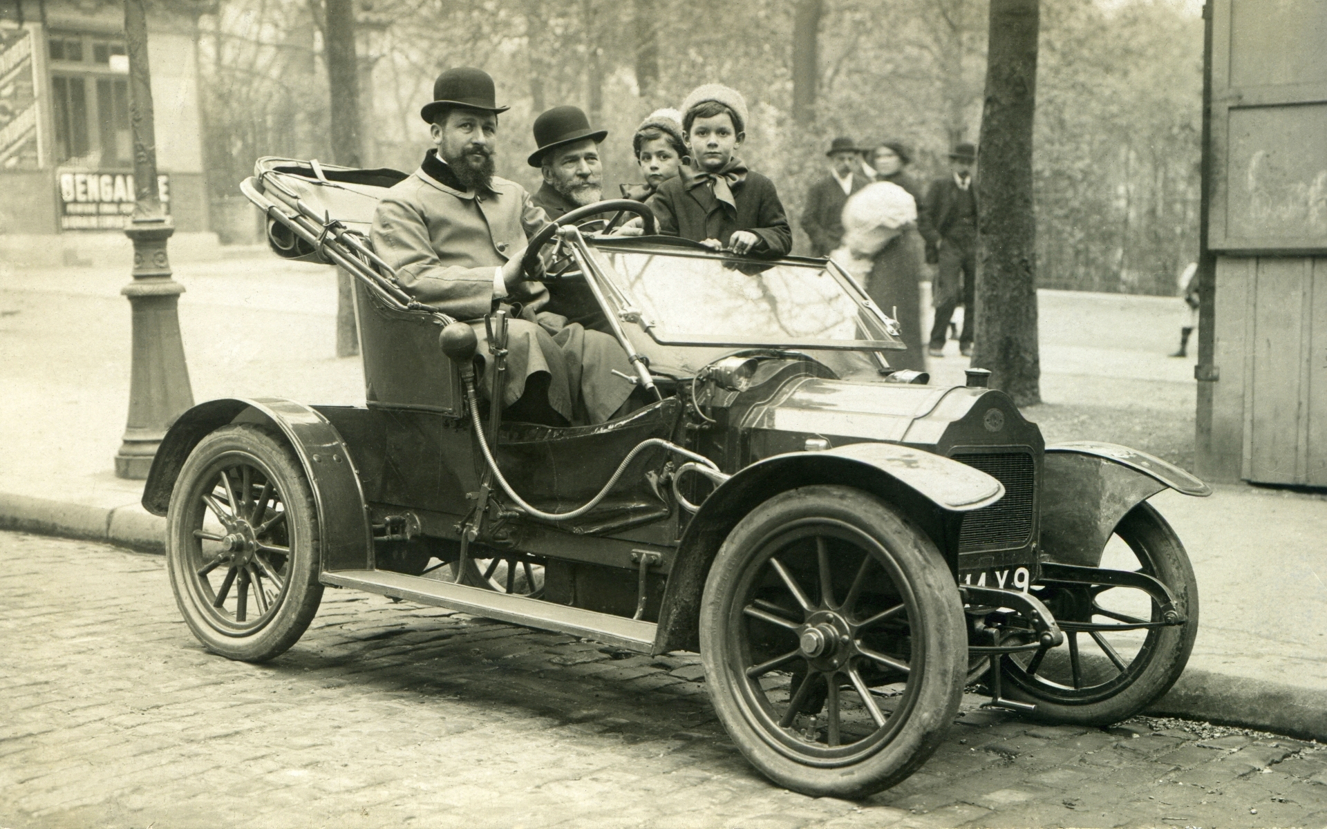 Photograph of 2 men and 2 children in an automobile, Paris.