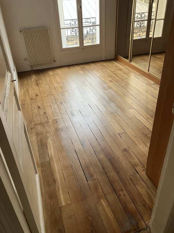 François Gaillard, independent floor sanding craftsman, working with HTC Husqvarna planetary sanding machine on a hardwood parquet floor in Paris, France.